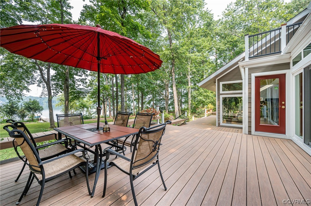 13714 Winterberry Ridge Midlothian, VA 23112 - Photo 33 of 49 a view of a deck with table and chairs under an umbrella with wooden floor and fence