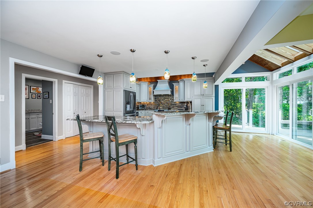 13714 Winterberry Ridge Midlothian, VA 23112 - Photo 7 of 49 a kitchen with stainless steel appliances granite countertop a stove a refrigerator a kitchen island a dining table and chairs with wooden floor