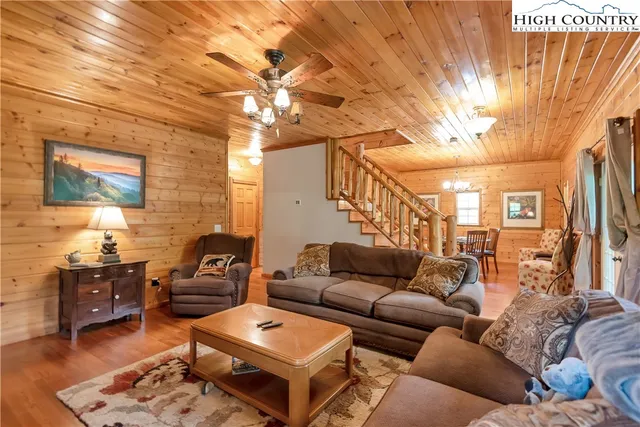 a kitchen with stainless steel appliances granite countertop a refrigerator a sink dishwasher a stove and a dining table with wooden floor