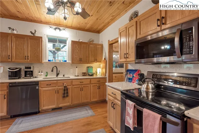 a kitchen with stainless steel appliances white cabinets and a stove top oven