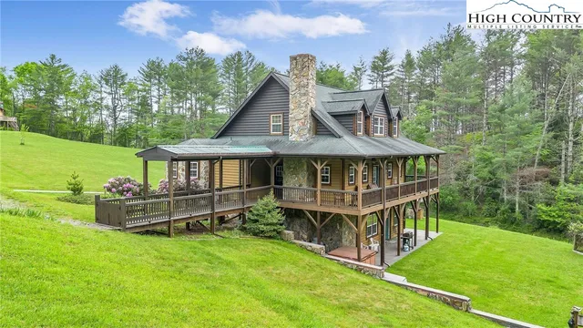 a view of a big house with a big yard and large trees