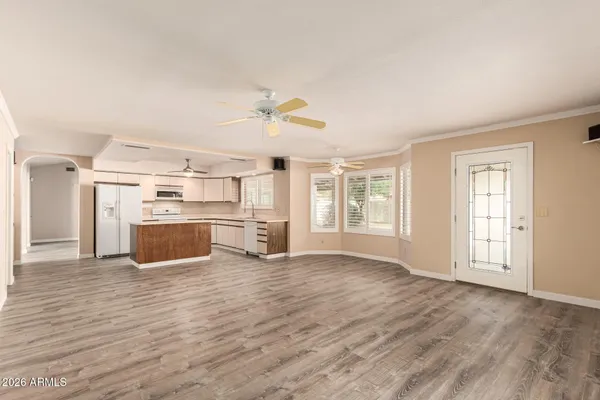 an empty room with wooden floor cabinet and windows