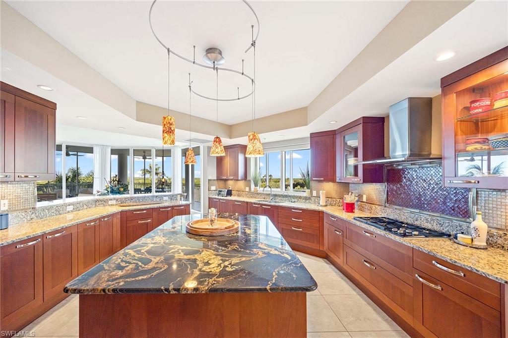 13675 Vanderbilt Drive, Unit 510 Naples, FL 34110 - Photo 13 of 37 a large kitchen with stainless steel appliances granite countertop a stove and cabinets