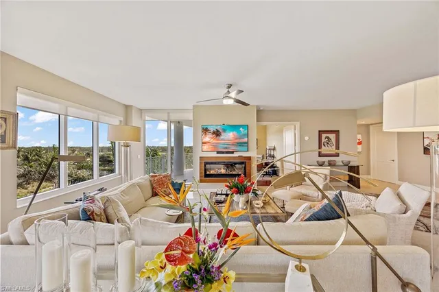 a living room with furniture a couch and a large window