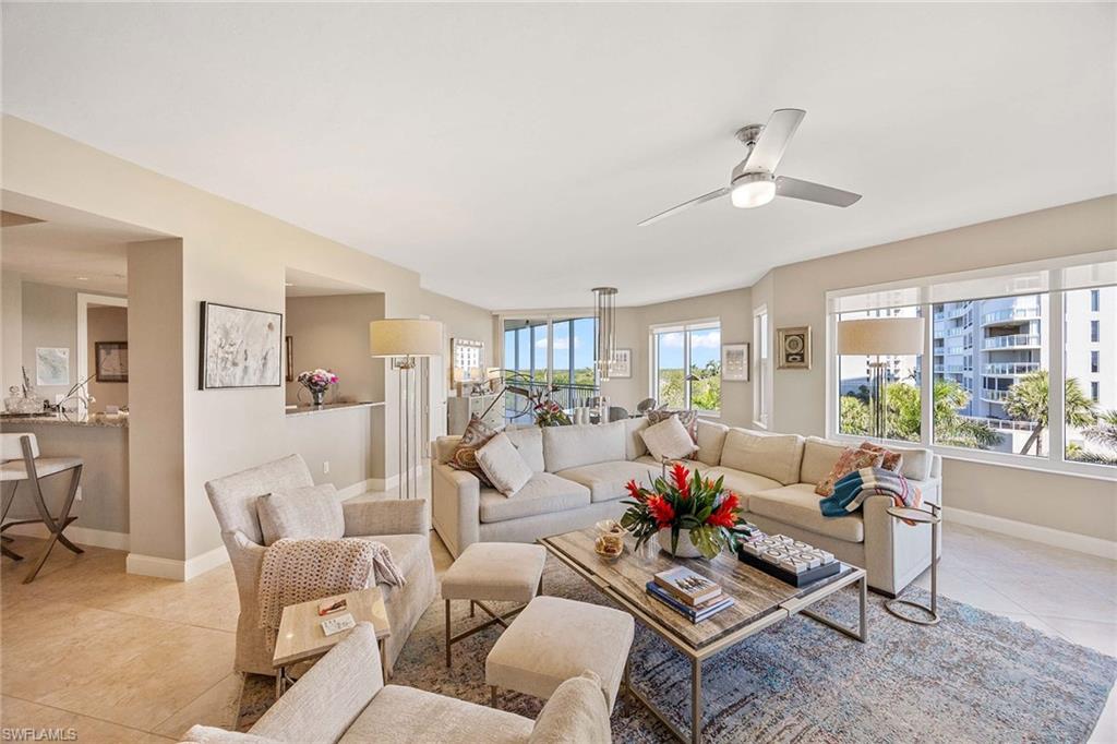 13675 Vanderbilt Drive, Unit 510 Naples, FL 34110 - Photo 16 of 37 a living room with furniture or couches and a dining table with wooden floor