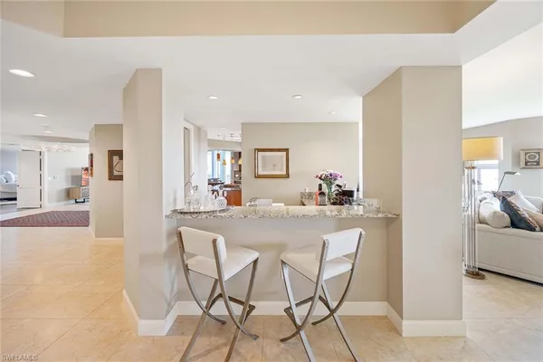 a dining hall with stainless steel appliances a dining table and chairs