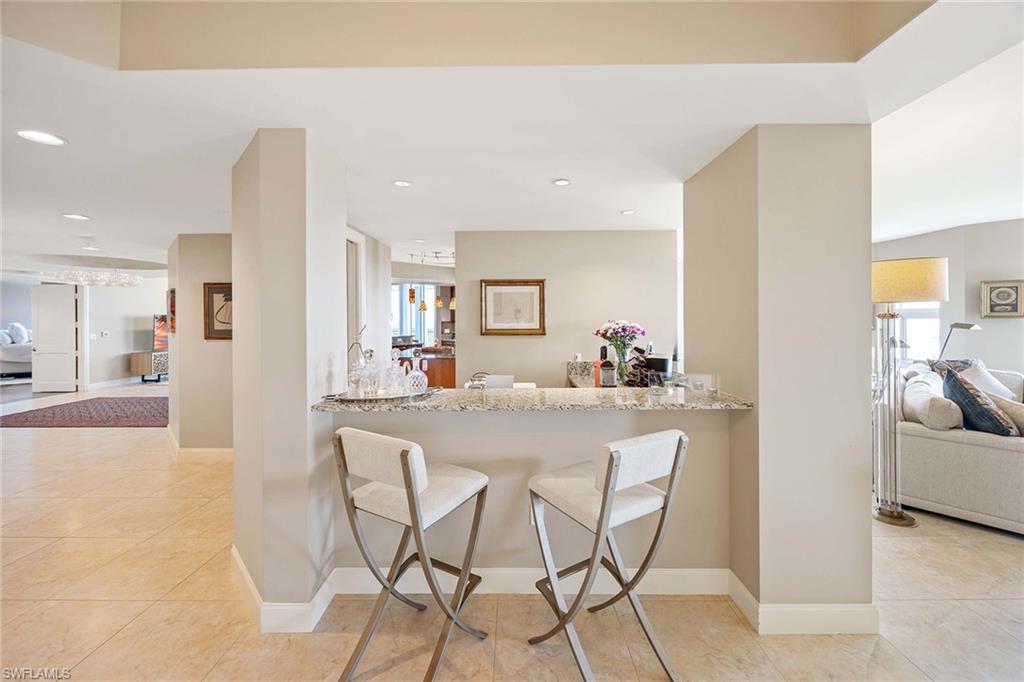 13675 Vanderbilt Drive, Unit 510 Naples, FL 34110 - Photo 19 of 37 a dining hall with stainless steel appliances a dining table and chairs