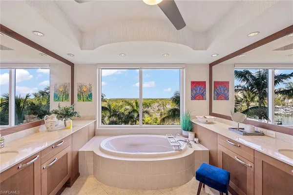 a bathroom with a sink a large mirror a bathtub and a sink