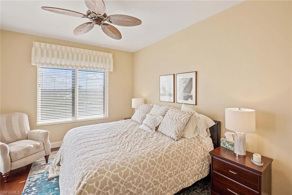 13675 Vanderbilt Drive, Unit 510 Naples, FL 34110 - Photo 27 of 37 a bedroom with a bed and wooden floor
