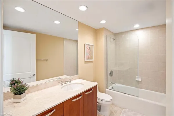 a bathroom with a granite countertop sink a toilet and shower