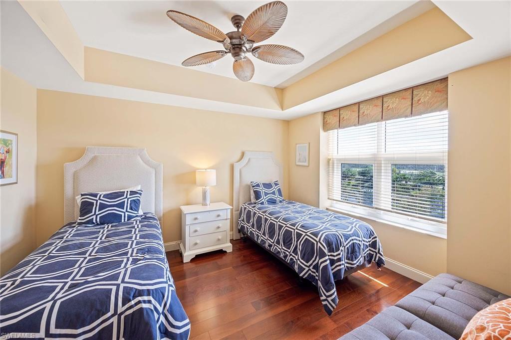 13675 Vanderbilt Drive, Unit 510 Naples, FL 34110 - Photo 29 of 37 a bed room with a bed and a chandelier