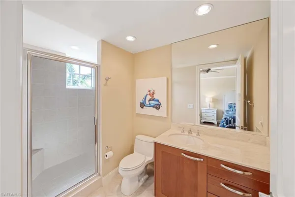 a spacious bathroom with a toilet a sink a mirror and a shower