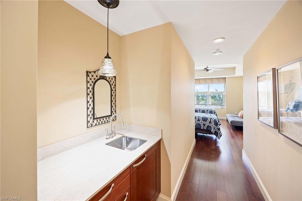 13675 Vanderbilt Drive, Unit 510 Naples, FL 34110 - Photo 31 of 37 a kitchen with a sink a counter top space and wooden floor