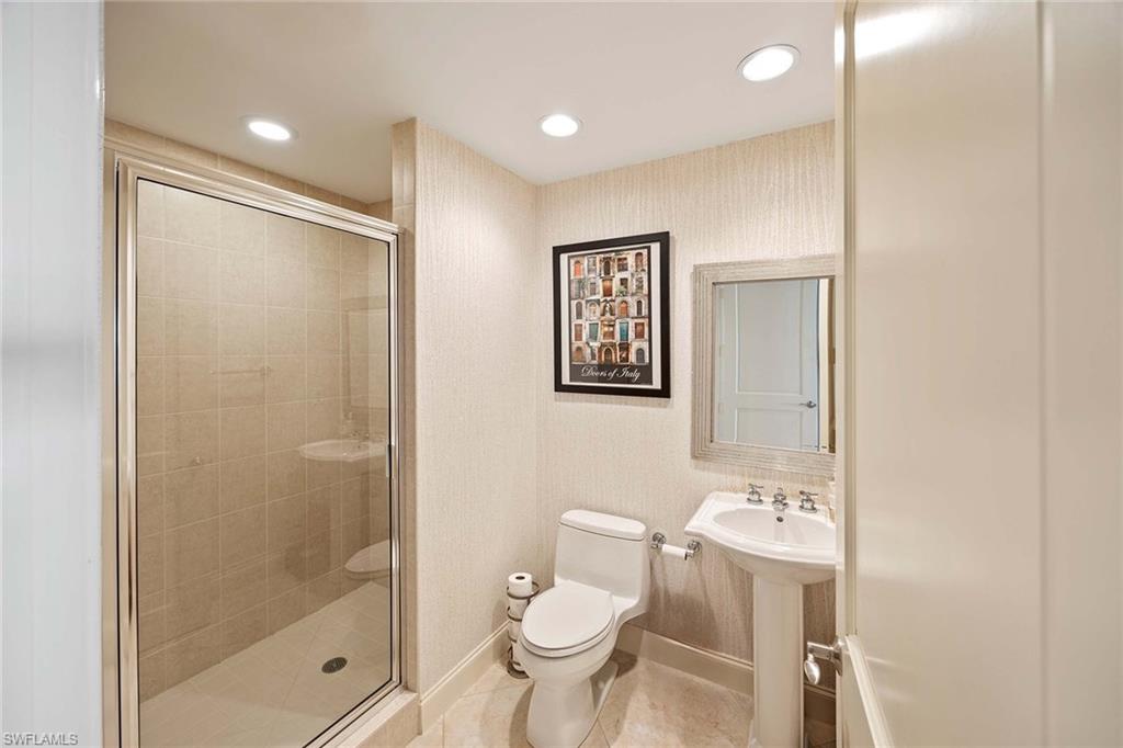 13675 Vanderbilt Drive, Unit 510 Naples, FL 34110 - Photo 32 of 37 a bathroom with a toilet sink and shower