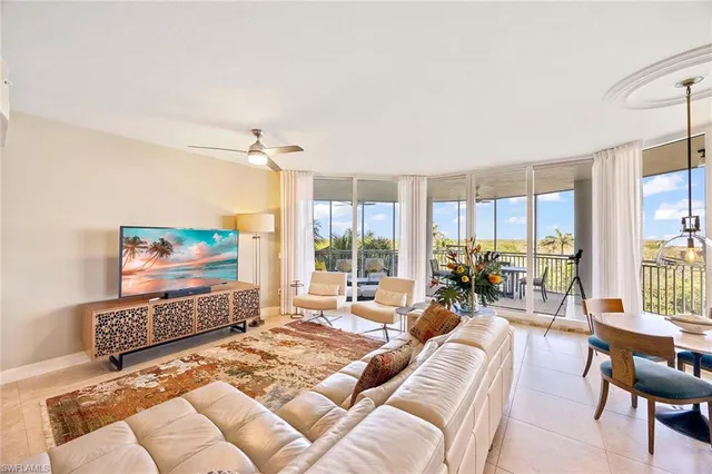 a living room with furniture large window and a flat screen tv