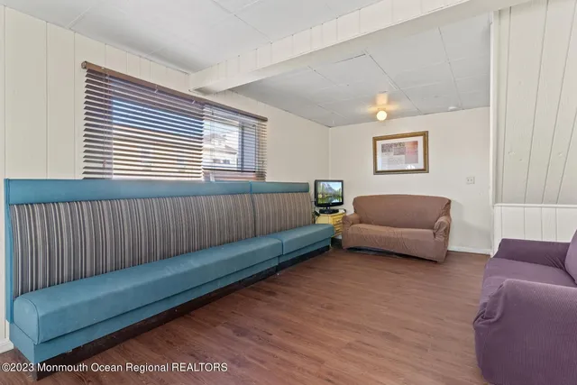 a kitchen with stainless steel appliances granite countertop a dining table chairs and a refrigerator