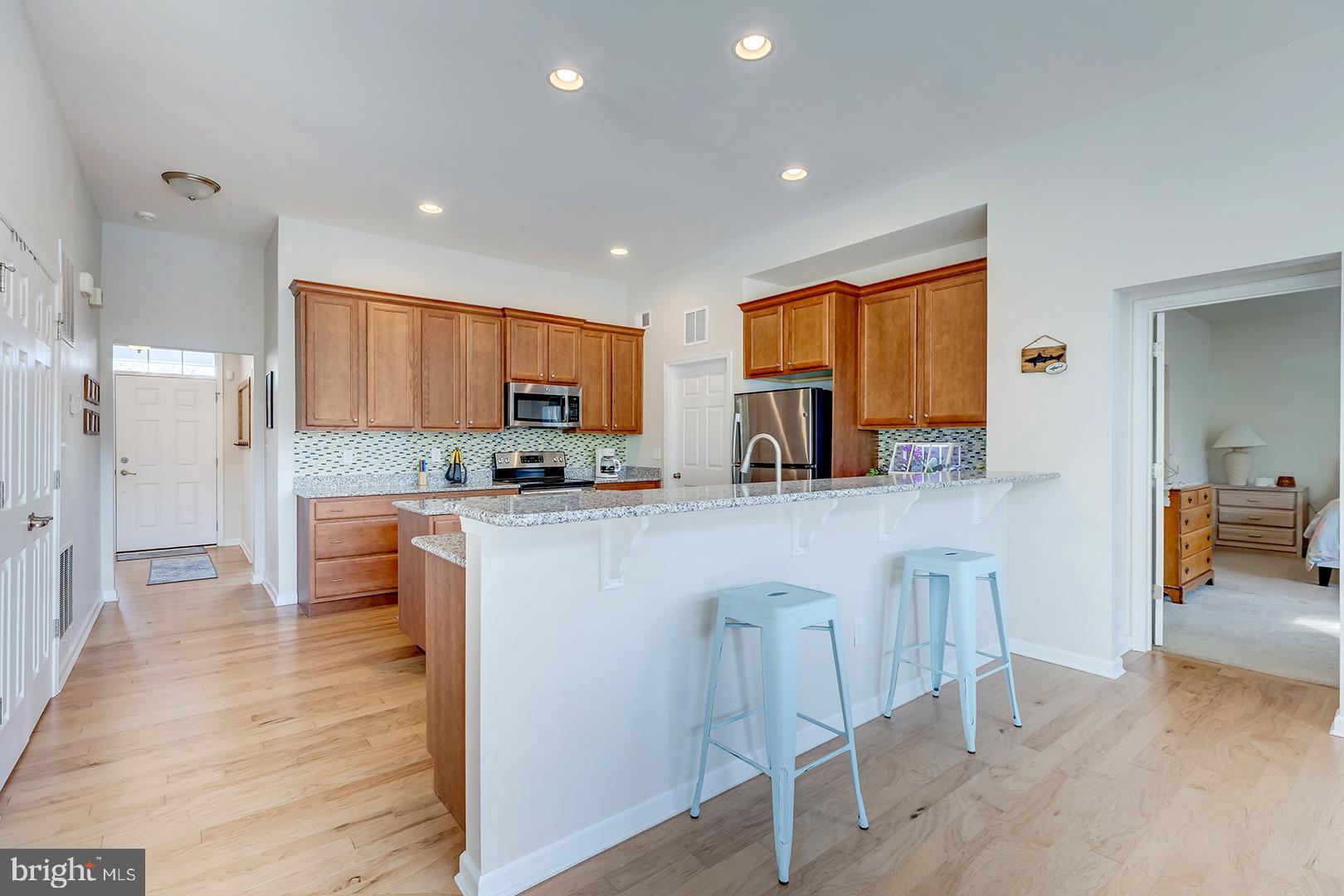 117 Carriage Drive Milton, DE 19968 - Photo 7 of 62 a kitchen with stainless steel appliances kitchen island granite countertop a stove a sink a refrigerator and cabinets