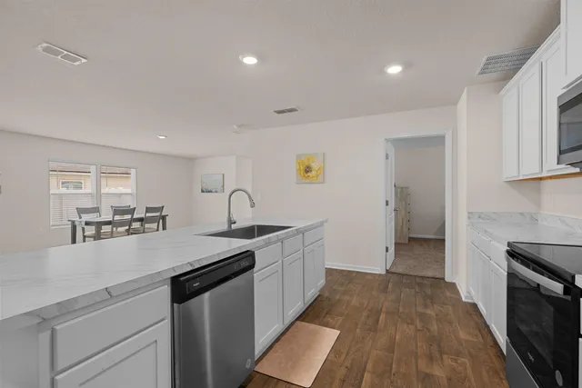 a kitchen with granite countertop a sink and a stove top oven