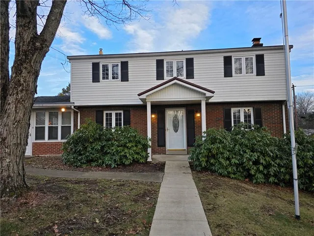 a front view of a house with yard and green space