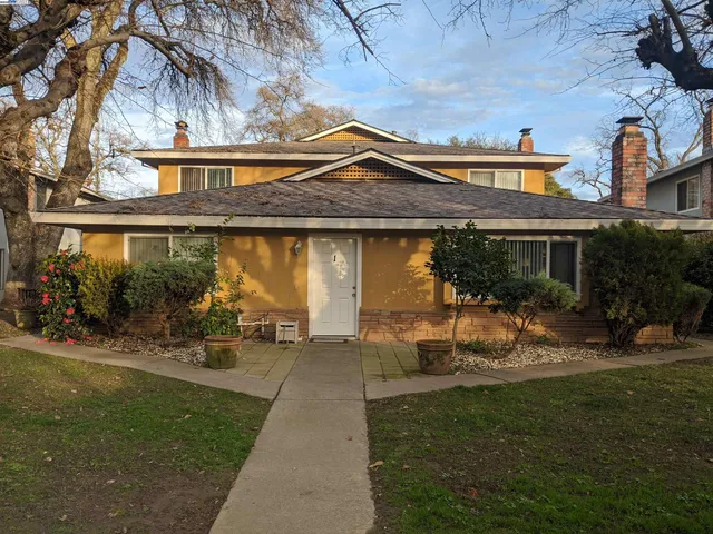 a view of a house with backyard and sitting area