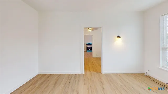 a view of empty room with wooden floor