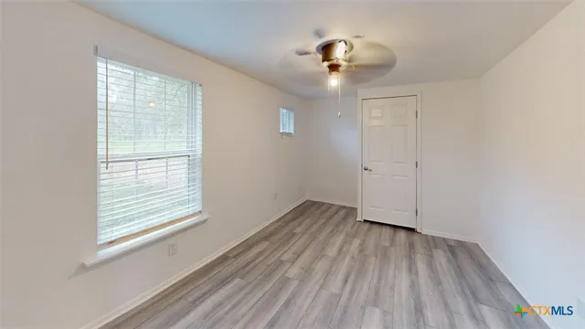 wooden floor in an empty room with a window