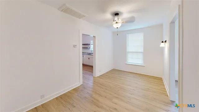 wooden floor in an empty room with a window