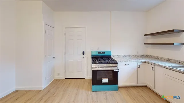 a kitchen with a stove top oven and cabinets
