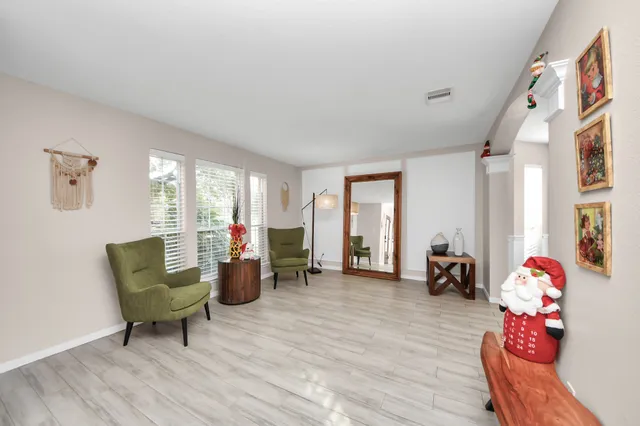 a living room with furniture and a wooden floor