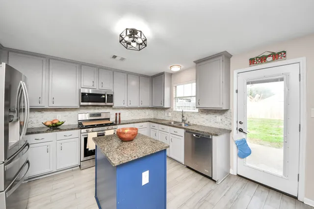 a kitchen with a sink a stove a refrigerator and cabinets