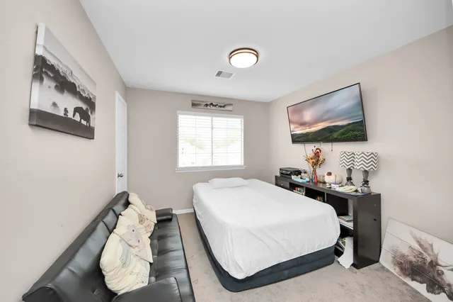 a bedroom with a bed and a flat screen tv