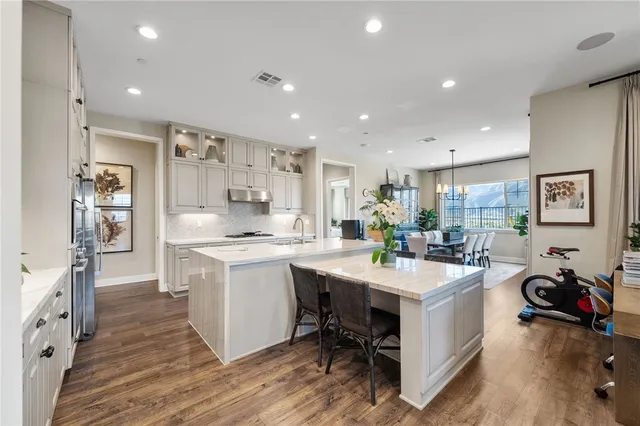 a kitchen with white cabinets and chairs