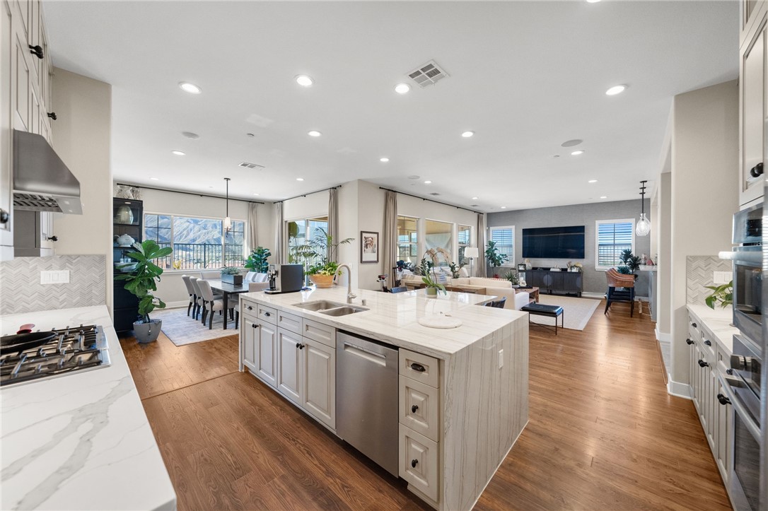 11463 Explorer Court Temescal Valley, CA 92883 - Photo 25 of 59 a large kitchen with kitchen island a sink a counter space and stainless steel appliances