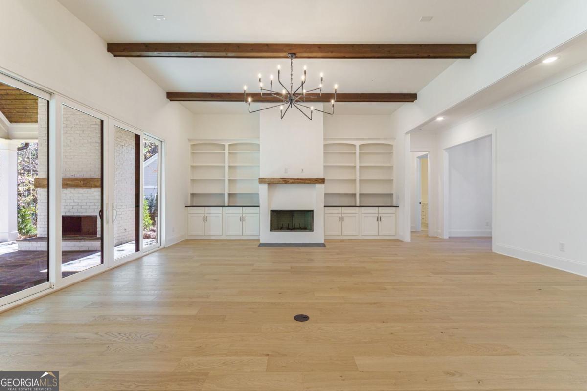 140 Parkside Lane Eatonton, GA 31024 - Photo 11 of 37 a view of a big room with a fireplace and chandelier