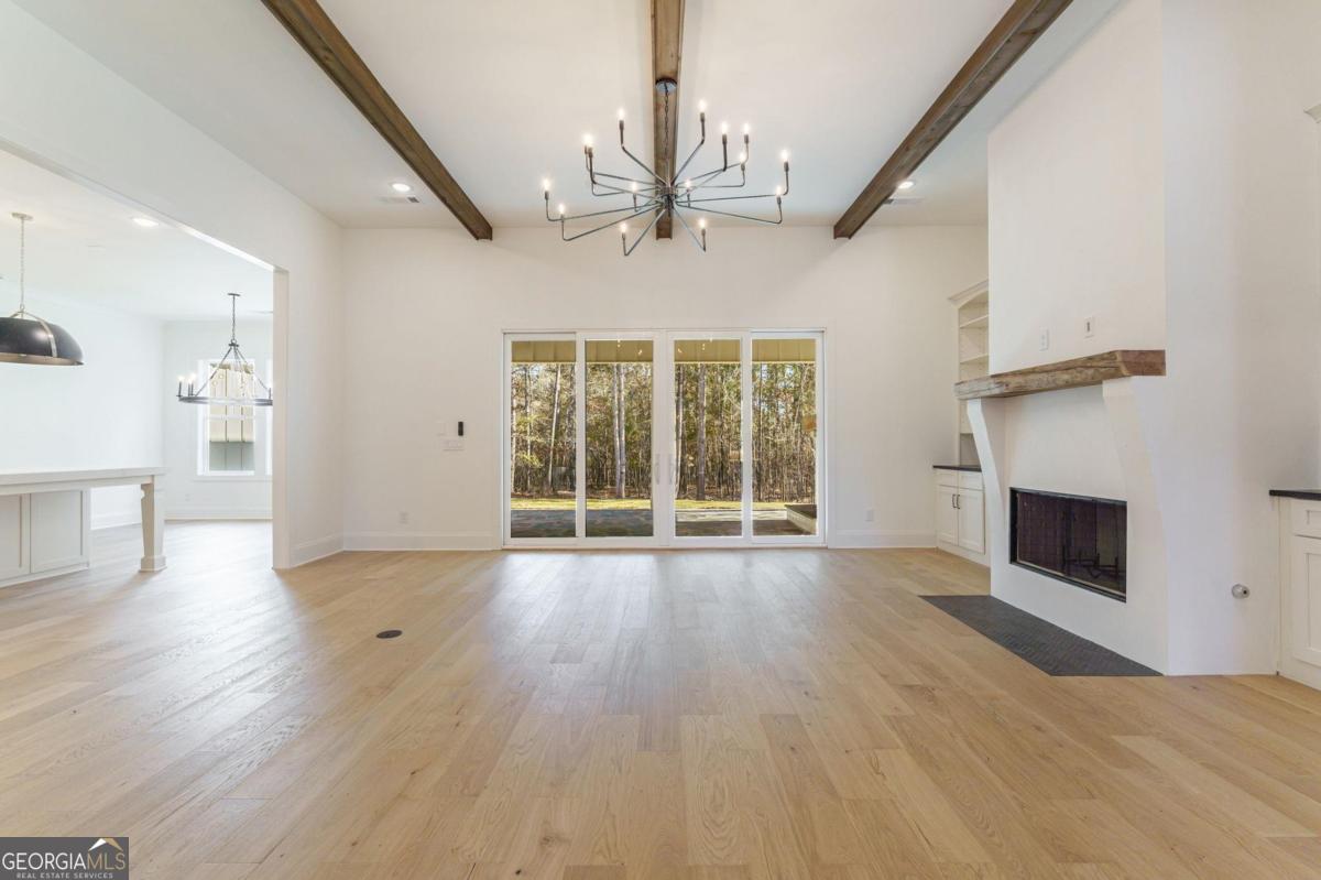 140 Parkside Lane Eatonton, GA 31024 - Photo 12 of 37 a view of empty room with wooden floor and fireplace