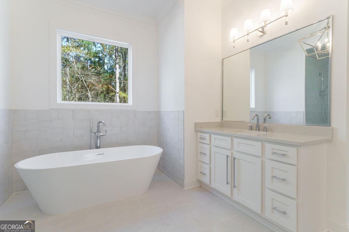 140 Parkside Lane Eatonton, GA 31024 - Photo 16 of 37 a bathroom with a white tub a sink and a window