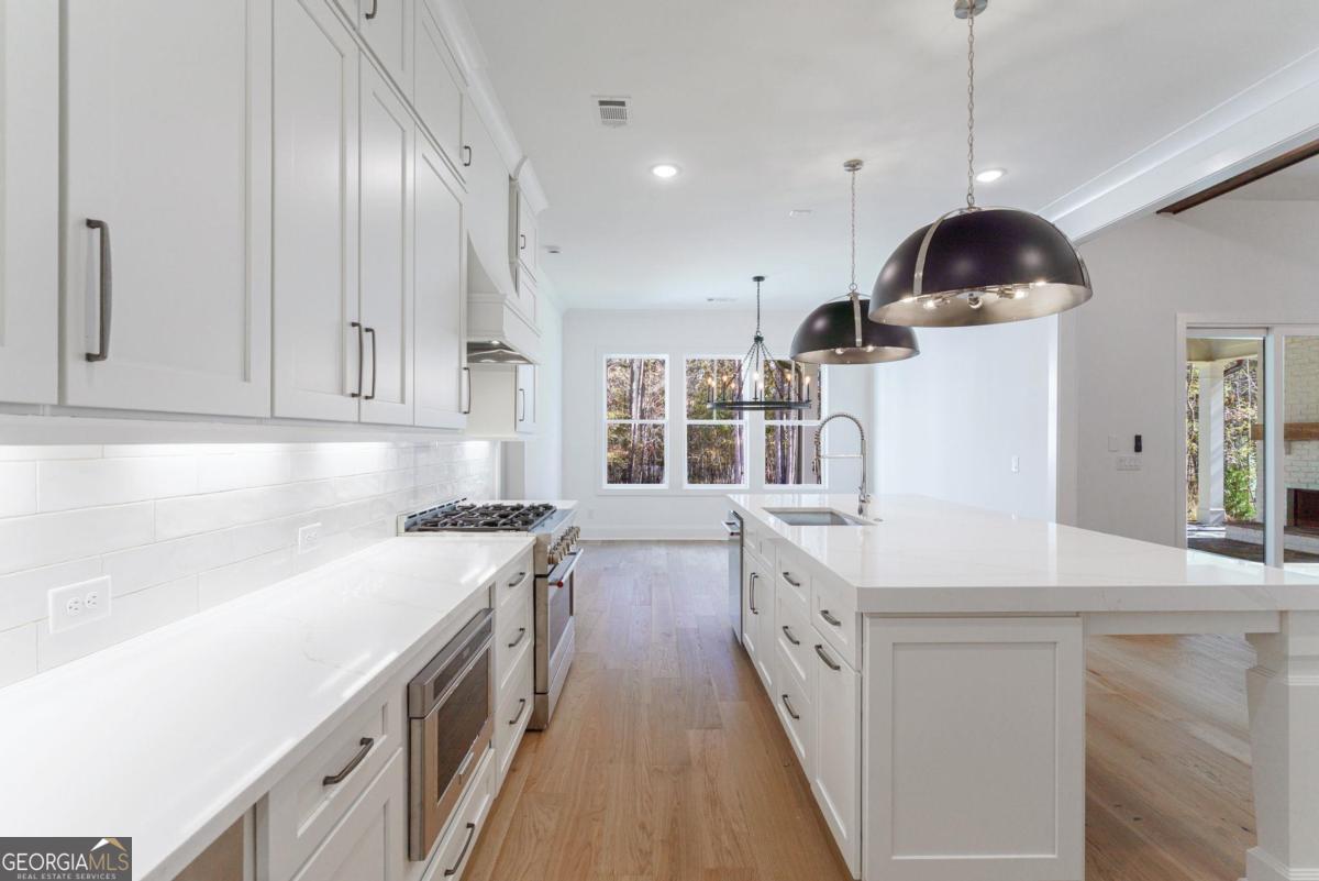 140 Parkside Lane Eatonton, GA 31024 - Photo 26 of 37 a kitchen with stainless steel appliances a sink a stove and a wooden floors