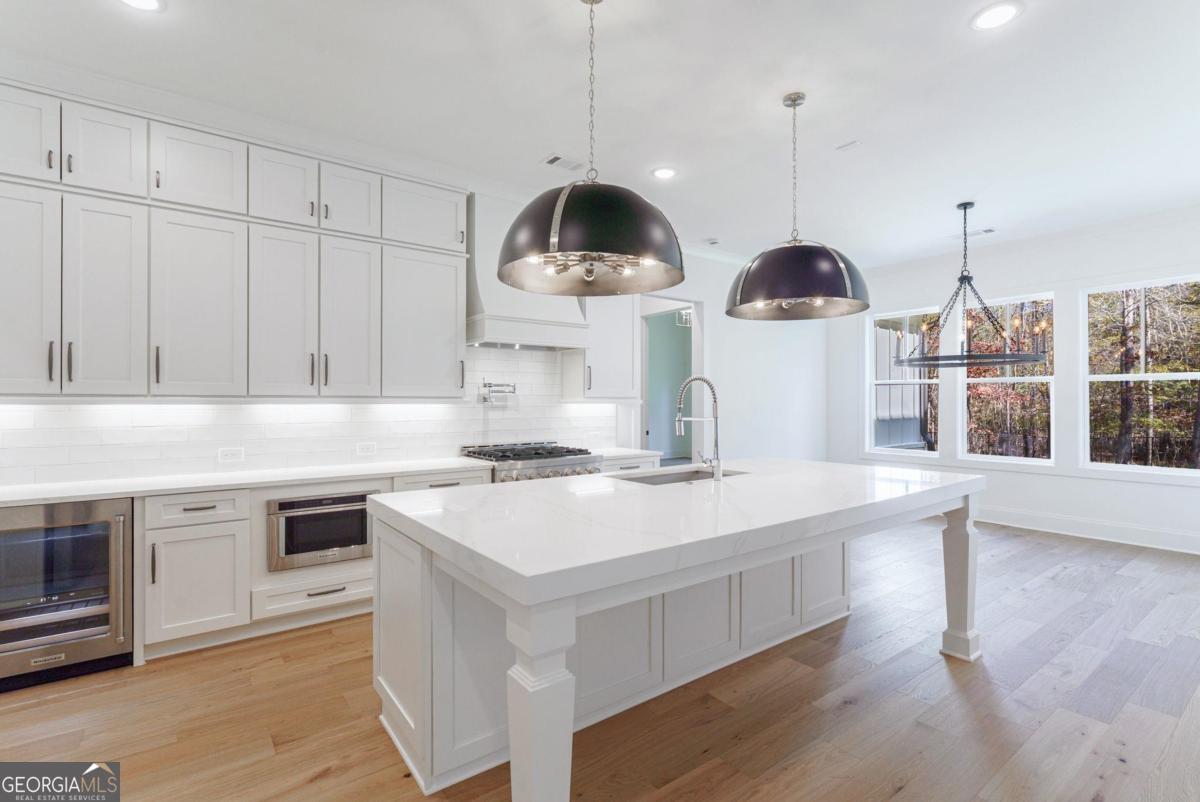 140 Parkside Lane Eatonton, GA 31024 - Photo 27 of 37 a kitchen with stainless steel appliances a stove a sink and a wooden floor