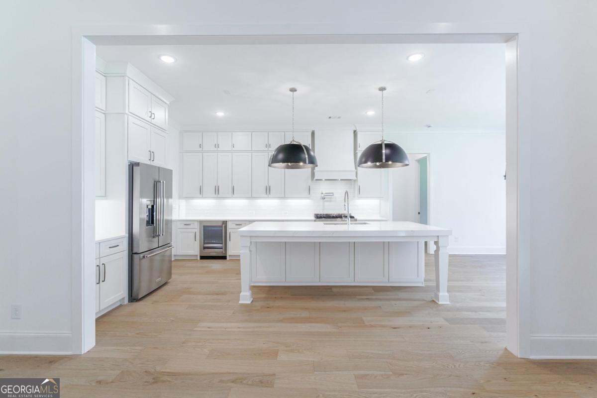 140 Parkside Lane Eatonton, GA 31024 - Photo 28 of 37 a view of kitchen with center island stainless steel appliances cabinets and living room view