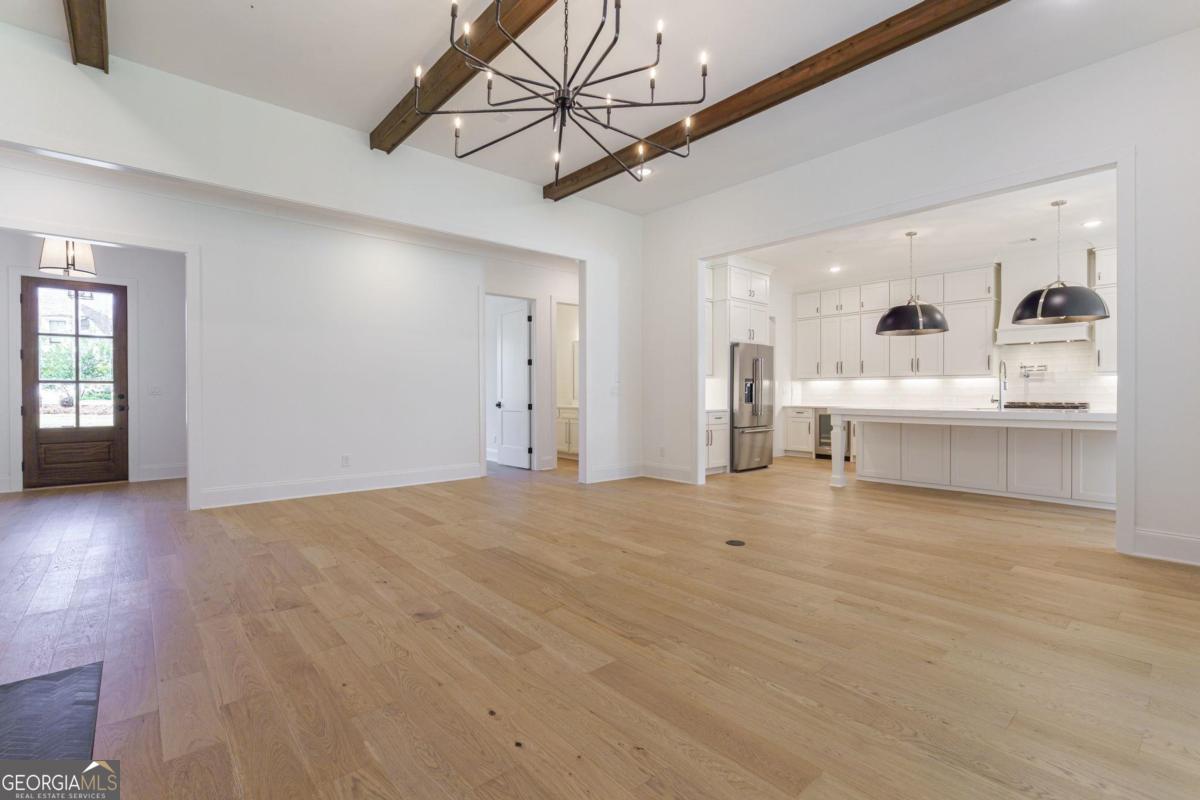 140 Parkside Lane Eatonton, GA 31024 - Photo 9 of 37 a view of open kitchen with granite countertop a white cabinets and chandelier