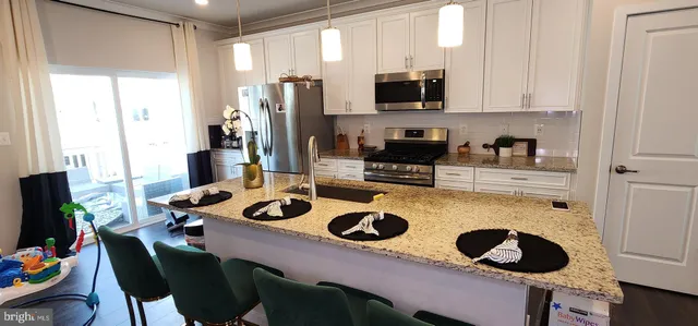 a kitchen with a refrigerator a stove a sink and a stove with wooden floor