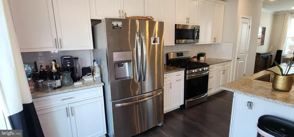 a kitchen with stainless steel appliances granite countertop a refrigerator stove and sink