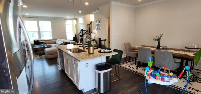 a kitchen filled with a white appliances wooden floor and a dining table