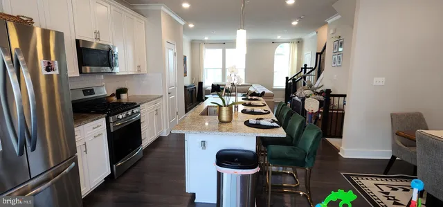 a kitchen with stainless steel appliances kitchen island granite countertop a refrigerator and a stove top oven