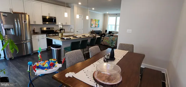 a kitchen with stainless steel appliances kitchen island granite countertop a dining table and chairs