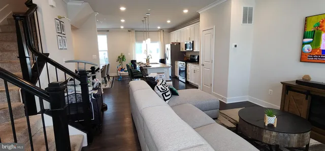 a living room with furniture a flat screen tv and a table