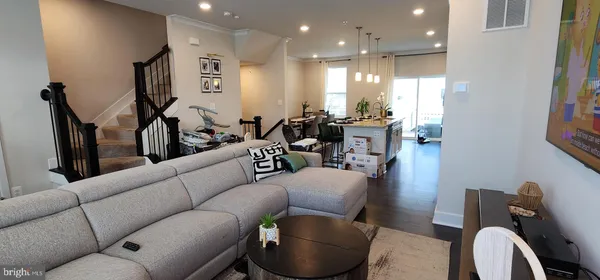 a living room with furniture a rug and kitchen view