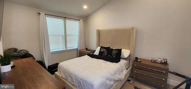 a bedroom with a bed and a flat tv screen on dresser