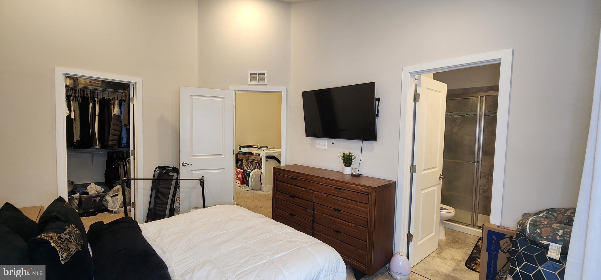 2 2nd, Unit 201 Lewes, DE 19958 - Photo 38 of 48 a bedroom with a bed and a flat tv screen on wall