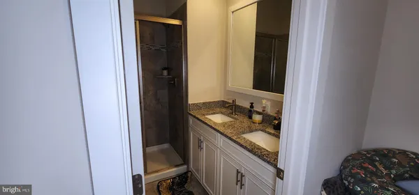 a bathroom with a granite countertop sink and a mirror